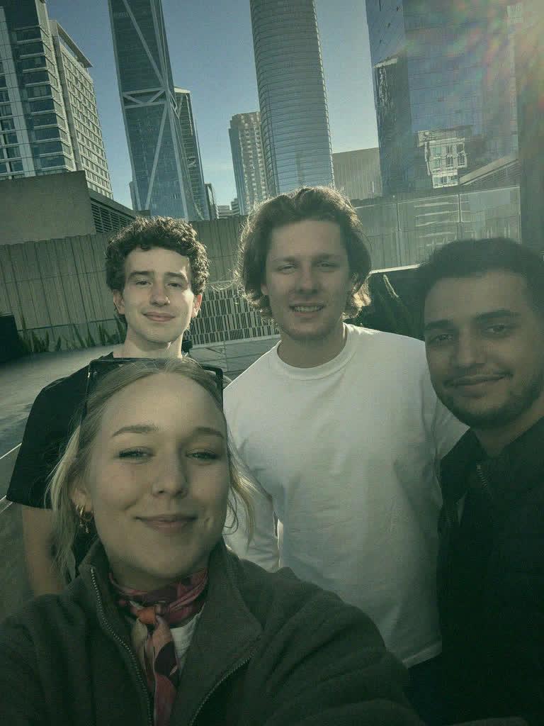 Four of the team on a rooftop, downtown San Francisco behind them